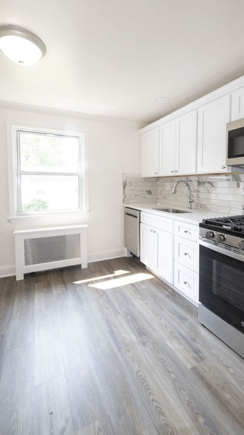 A kitchen with white cabinets and a black stove top oven.