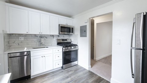 A kitchen with white cabinets and stainless steel appliances.