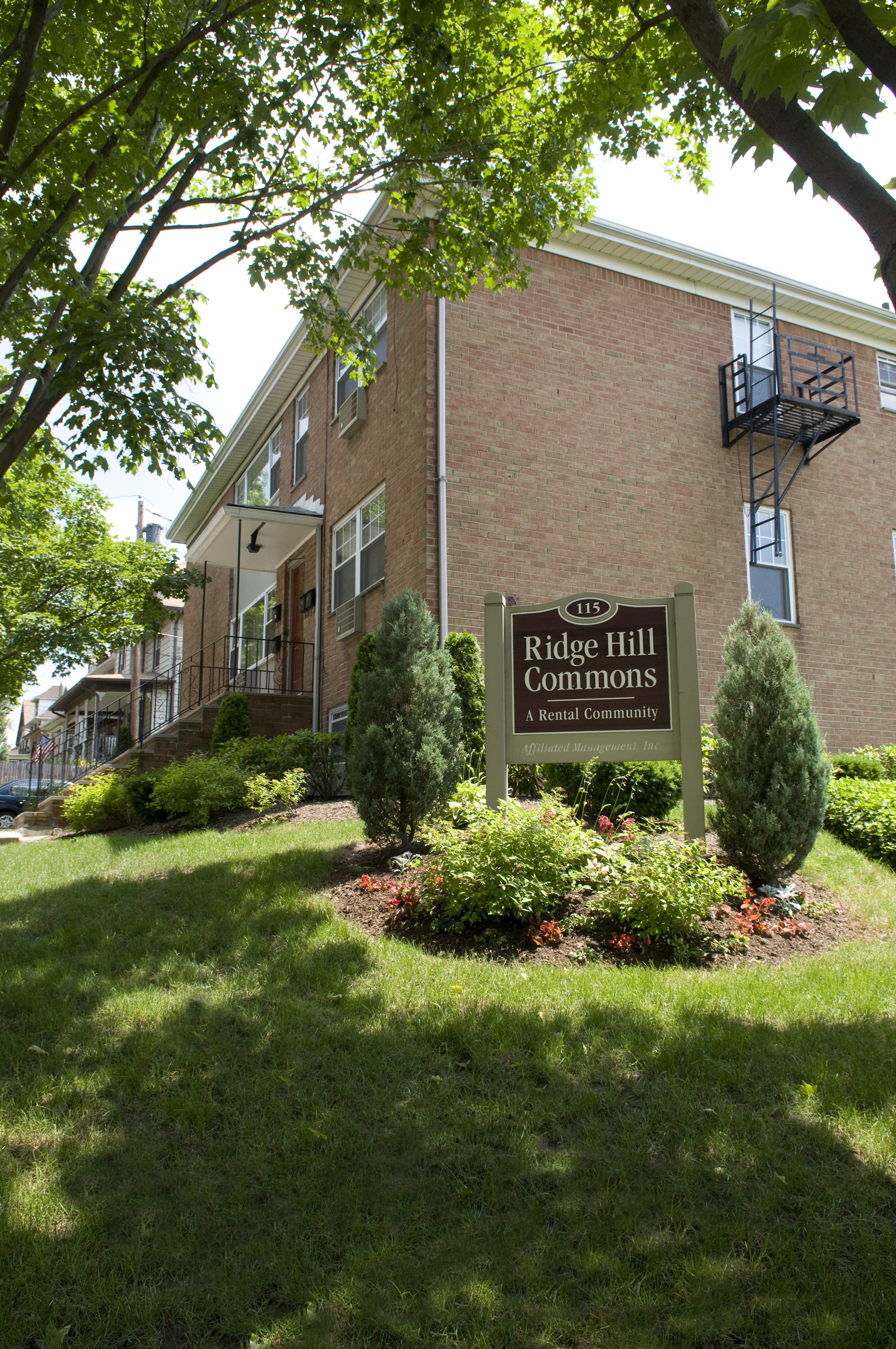 A sign for Ridge Hill Commons is in front of a brick building.