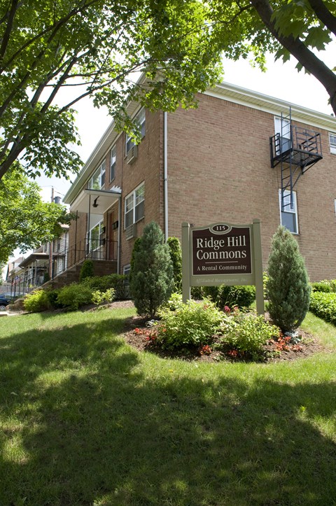 A sign for Ridge Hill Commons is in front of a brick building.