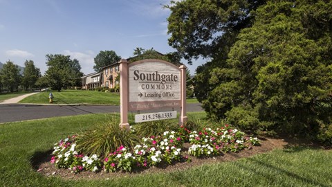 A sign for Southgate Commons in front of a building.