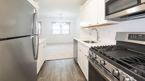 A modern kitchen with a stainless steel refrigerator and a black stove top oven.