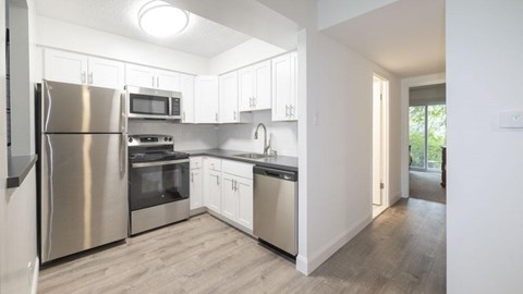 A modern kitchen with stainless steel appliances and white cabinets.