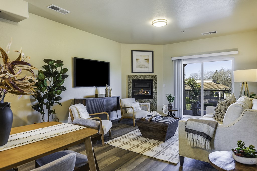 A living room with a fireplace and a flat screen TV.