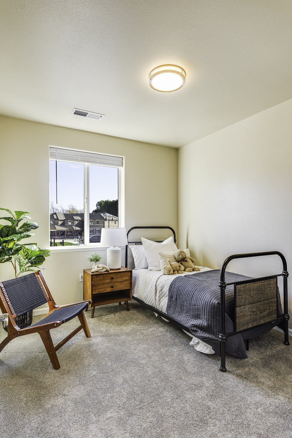 A bedroom with a bed, chair, and window.