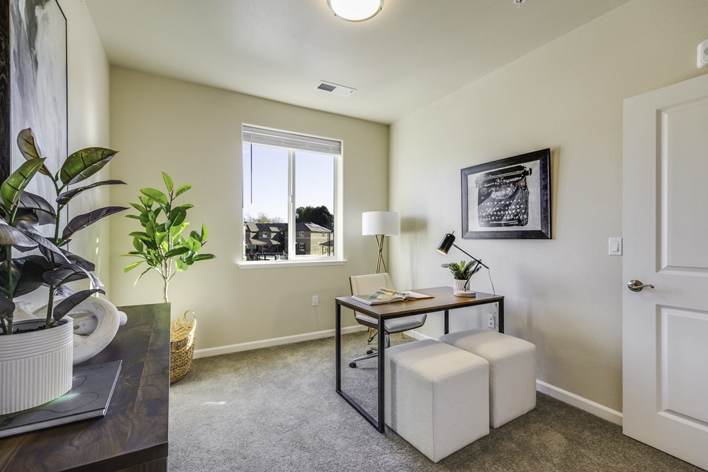 A room with a table, chair, and potted plant.