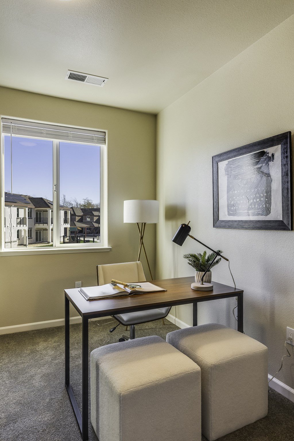 A room with a table, chairs, and a framed picture on the wall.