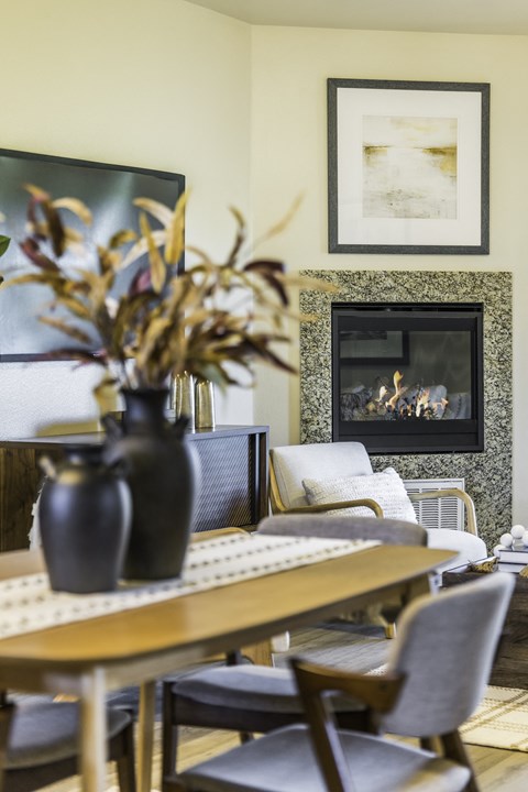 A dining room with a fireplace and a painting on the wall.