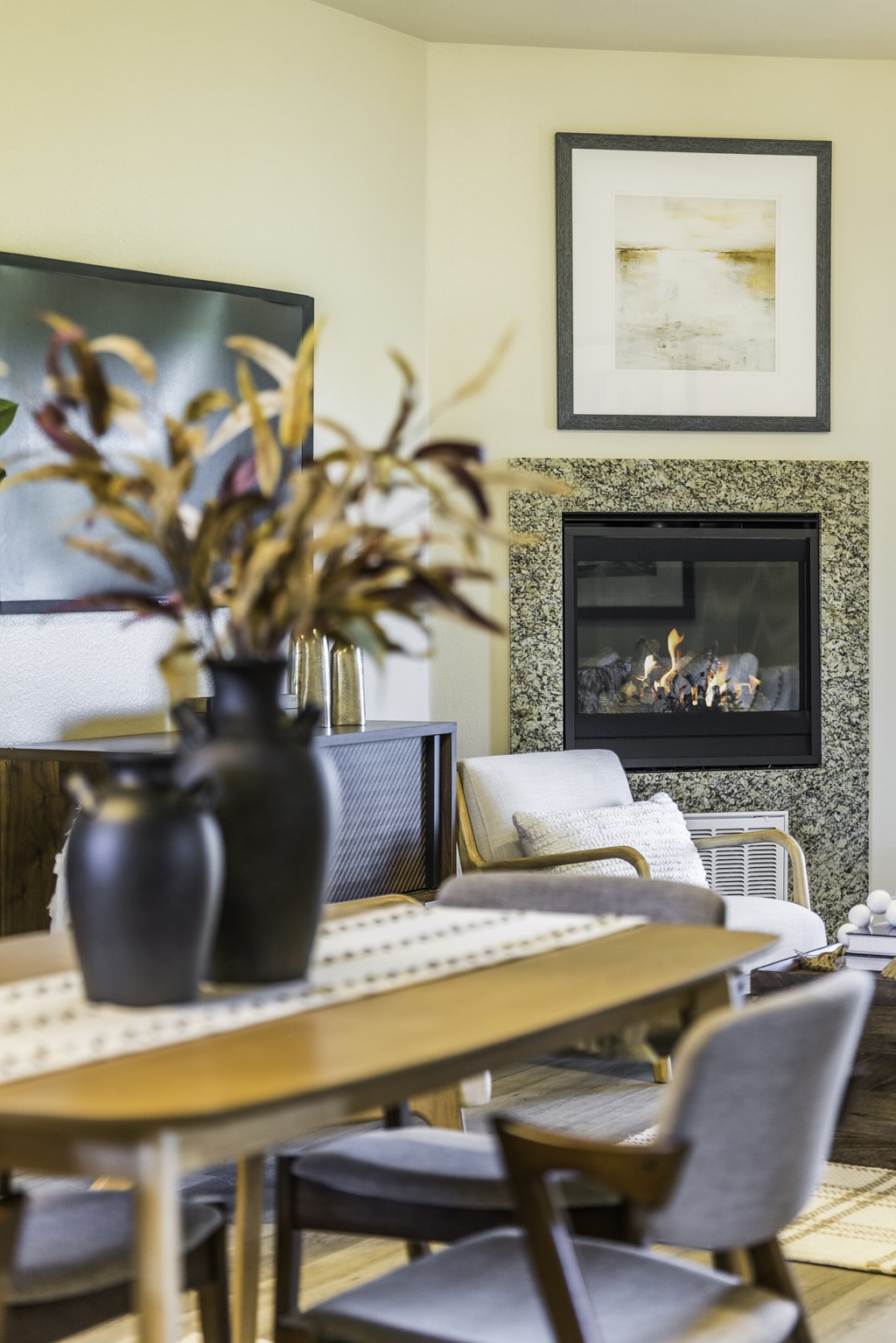 A dining room with a fireplace and a painting on the wall.