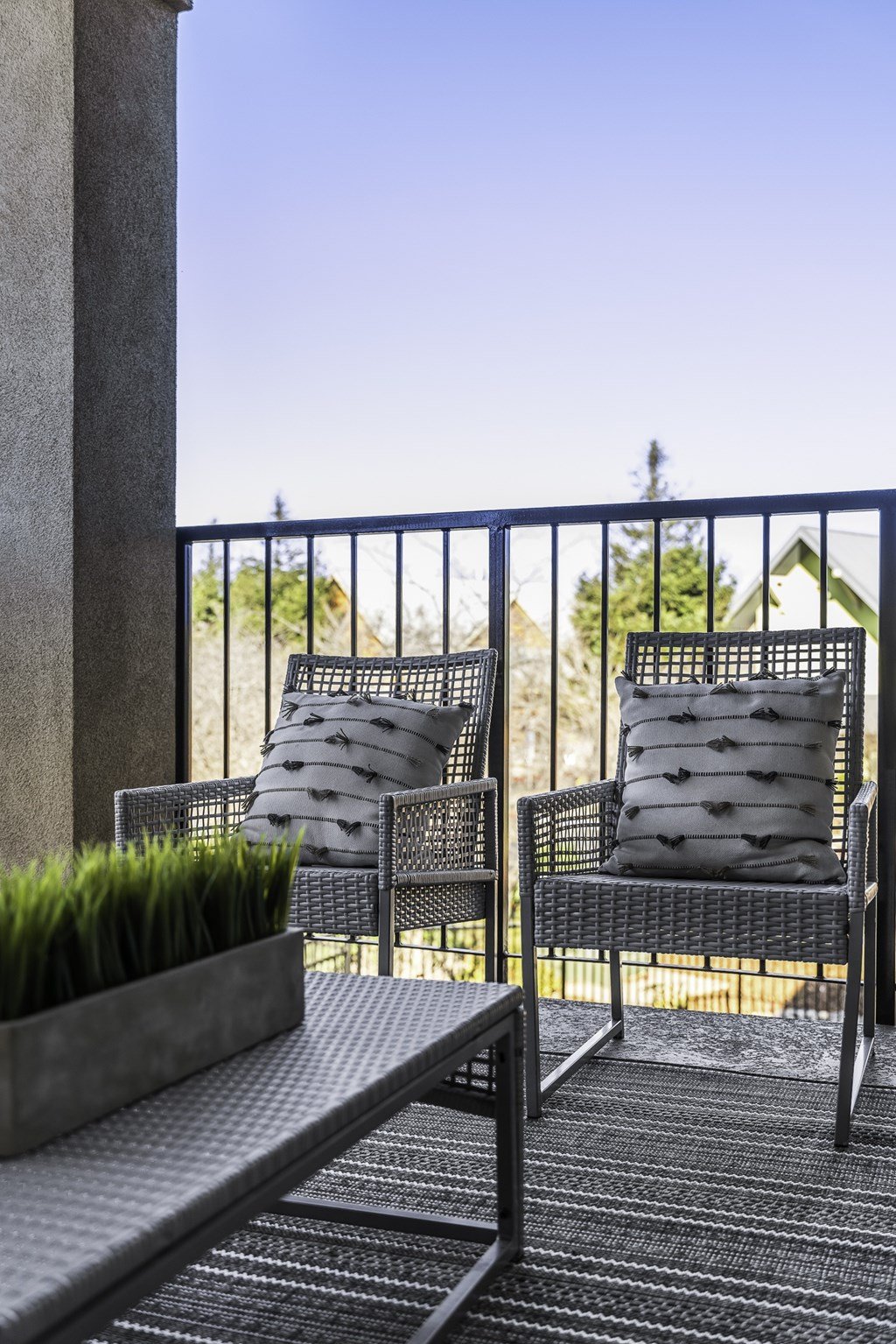Two chairs and a table on a balcony.