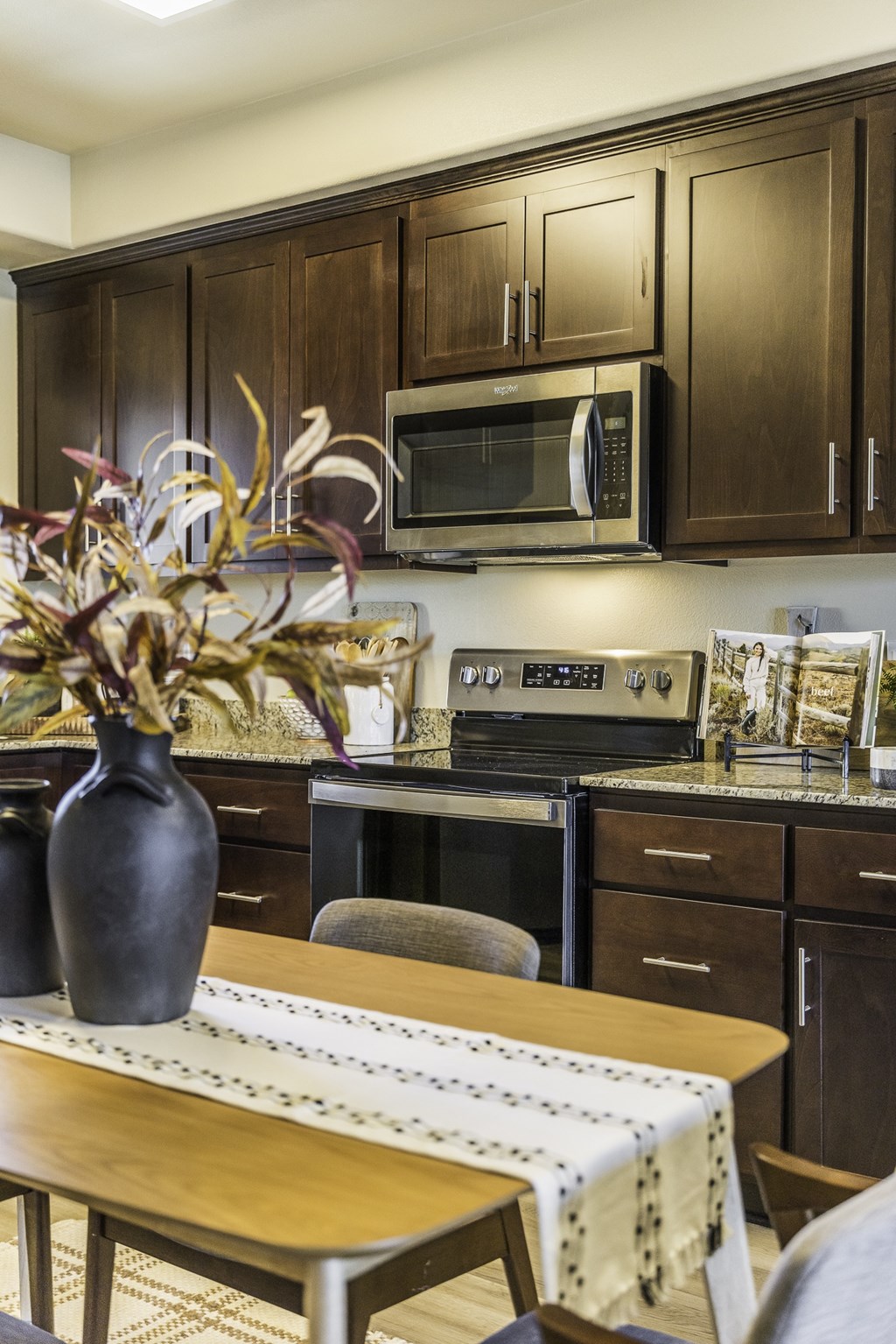 A kitchen with brown cabinets and a wooden table.