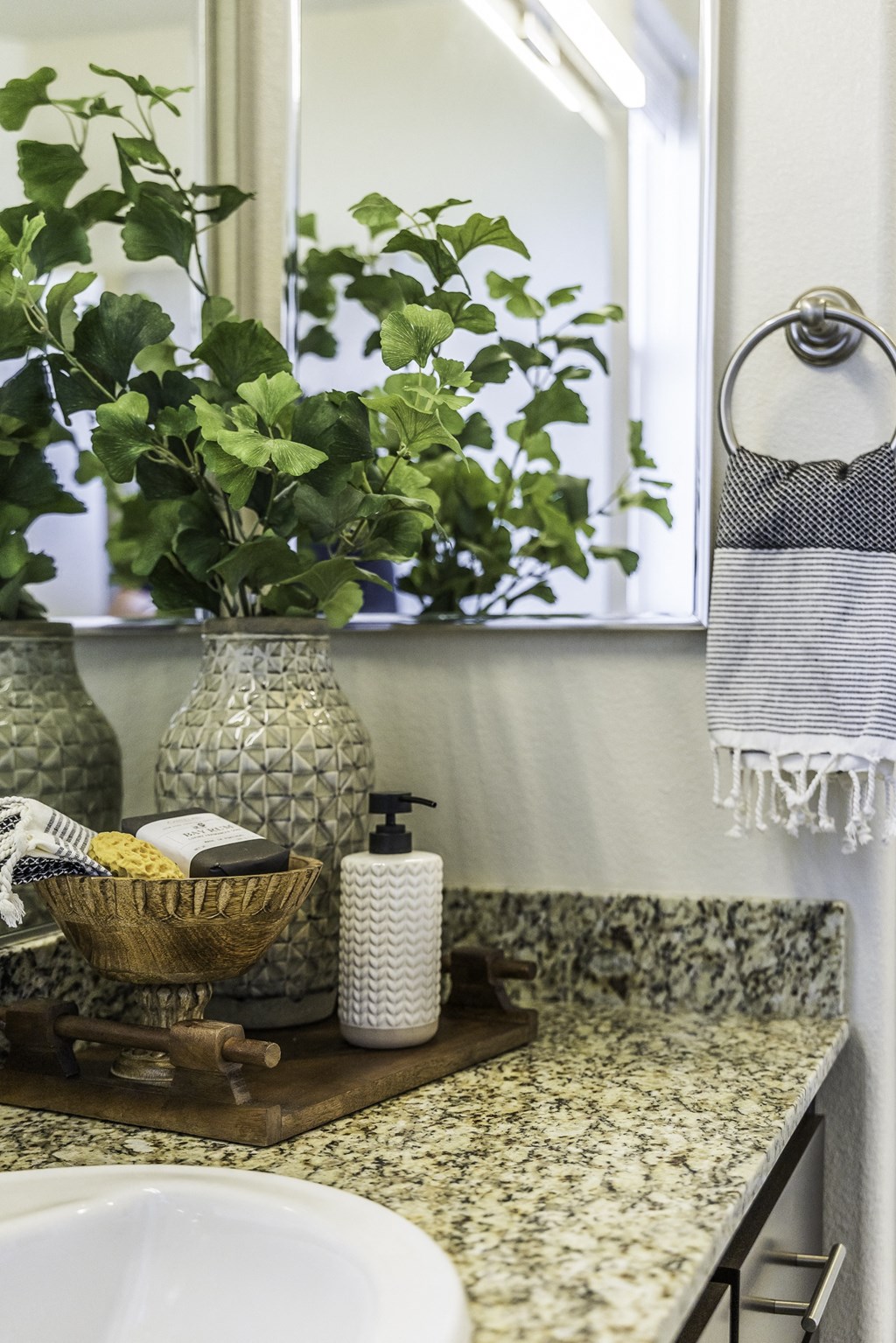 A bathroom with a green plant in a vase.