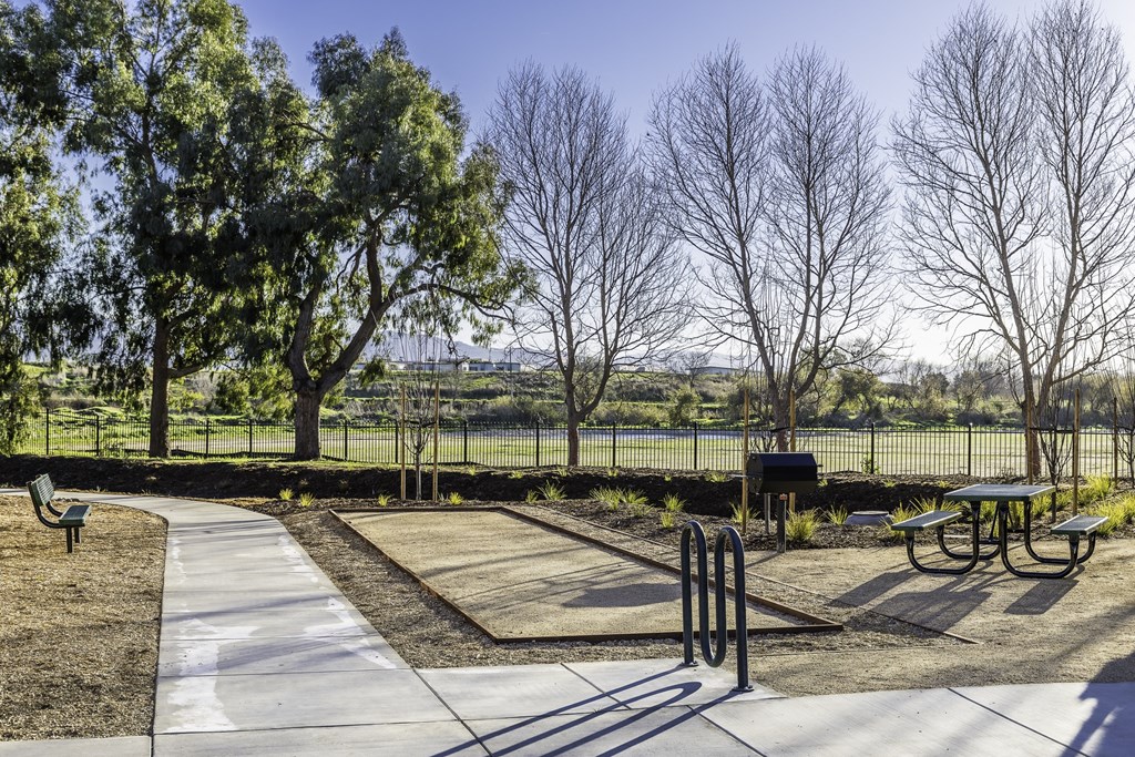 A park with a playground and picnic tables.