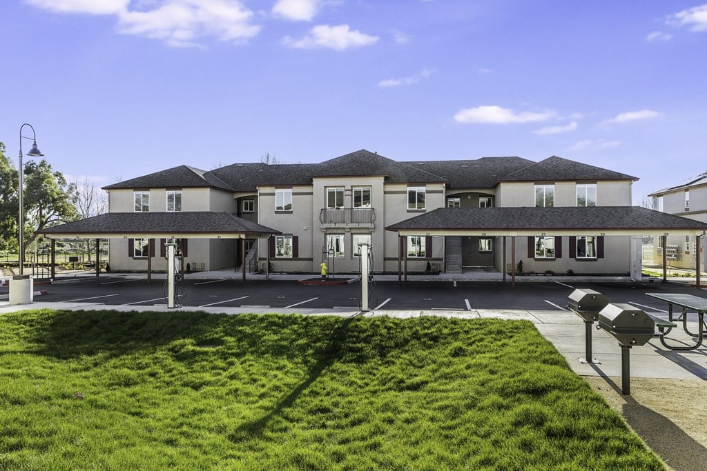 A large building with a green lawn in front.