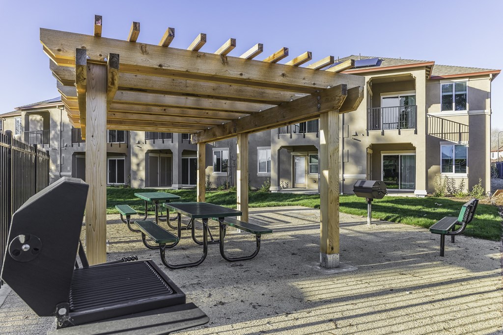 A wooden pergola is over a picnic table.