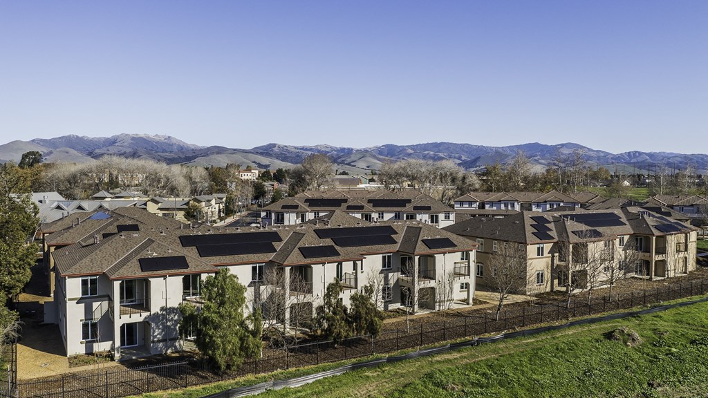 A row of houses with a mountain range in the background.