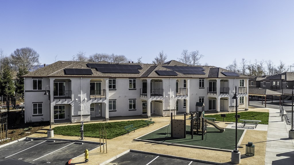 A large white building with a playground in front.