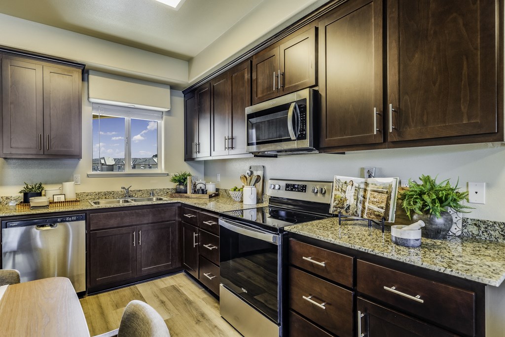 A kitchen with dark wood cabinets and granite countertops.