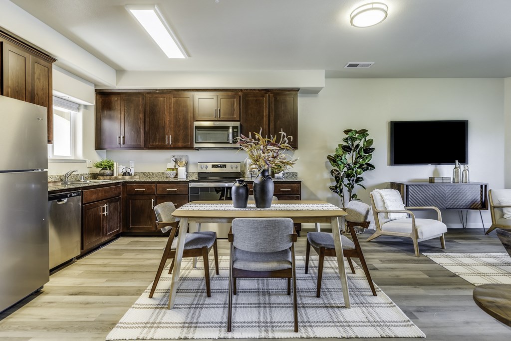 A modern kitchen with a dining table set for four.