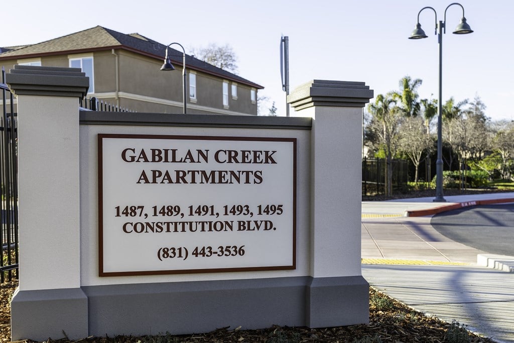 A sign for Gabilan Creek Apartments with a phone number on it.