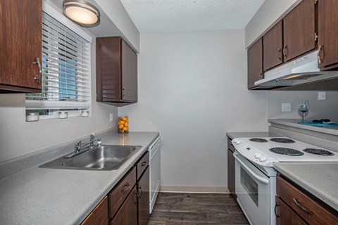 a kitchen with white appliances and wooden cabinets and a sink
