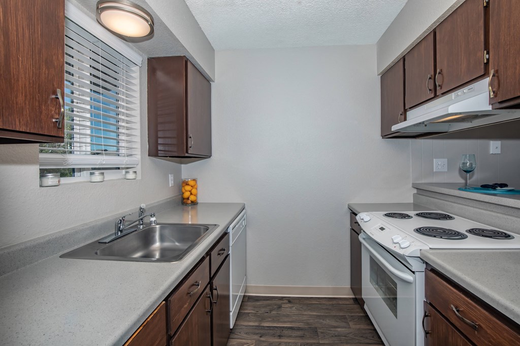 a kitchen with white appliances and wooden cabinets and a sink a kitchen with white appliances and wooden cabinets and a sink at Lincoln Village Apartments, Spokane, 99208