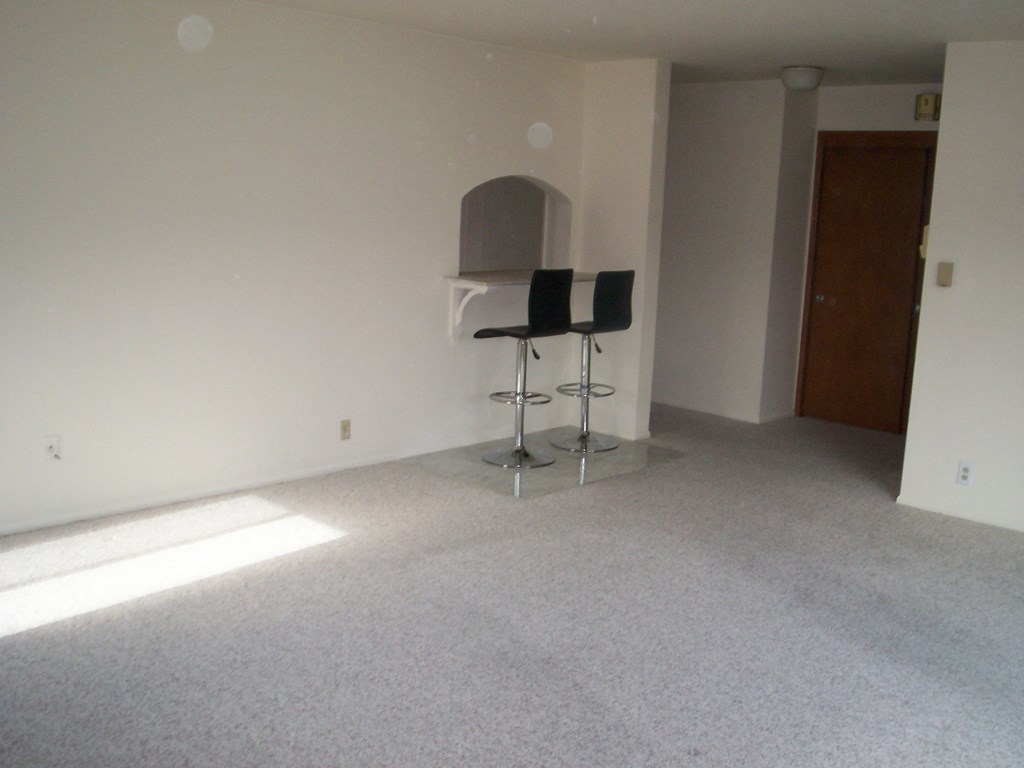 an empty room with chairs in the corner of a room