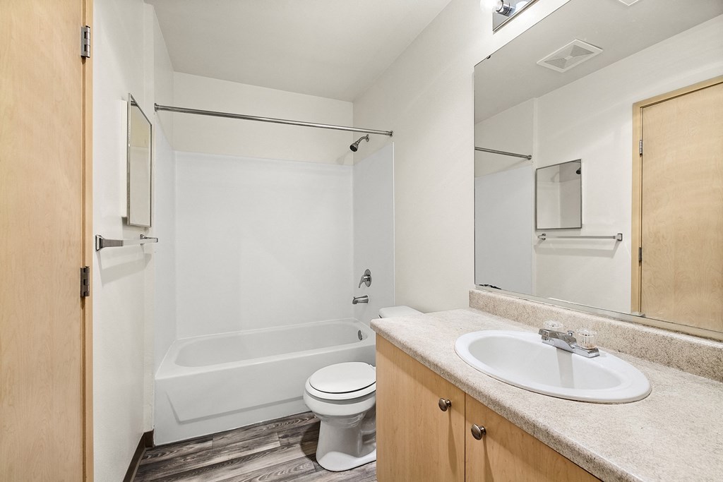a bathroom with a toilet sink and bathtub  at Mill Pond Apartments, Auburn, WA 98092