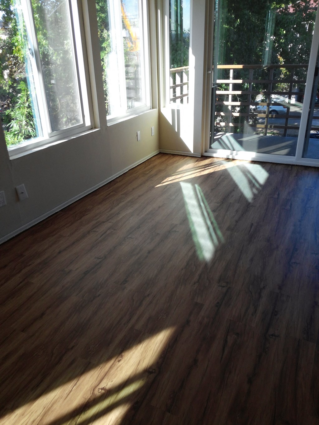 a living room with a hardwood floor and large windows