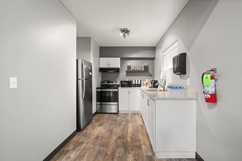 a kitchen with white cabinets and stainless steel appliances