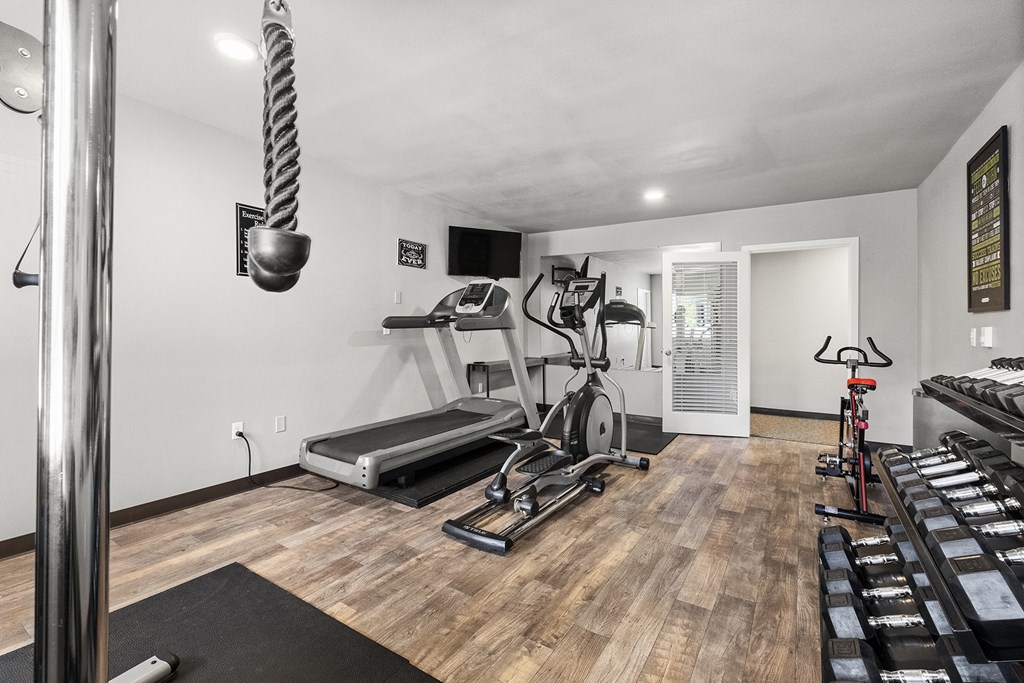 a home gym with a treadmill and weights at Mill Pond Apartments, Auburn, WA