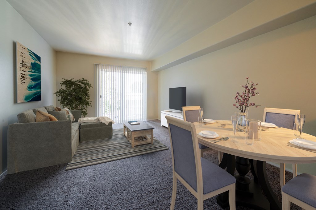 a dining area with a table and chairs and a living room with a couch and tv at Mill Pond Apartments, Auburn, WA
