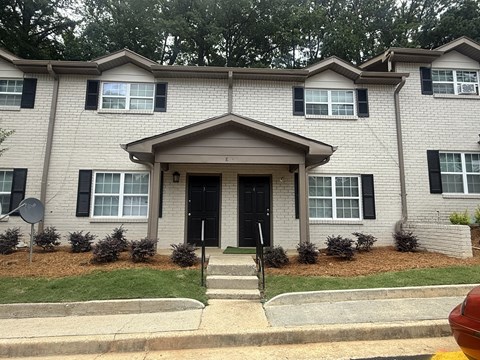 A two-story house with a black front door and windows with black frames at Waverly Manor Townhomes, Norcross, GA