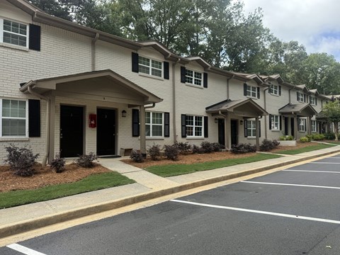A row of houses with a parking lot in front at Waverly Manor Townhomes, Norcross, GA 30071