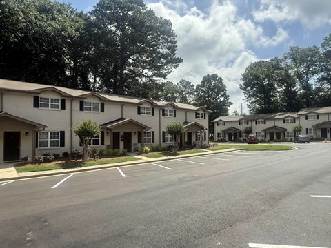 A row of houses with trees in the background at Waverly Manor Townhomes, Norcross, GA 30071