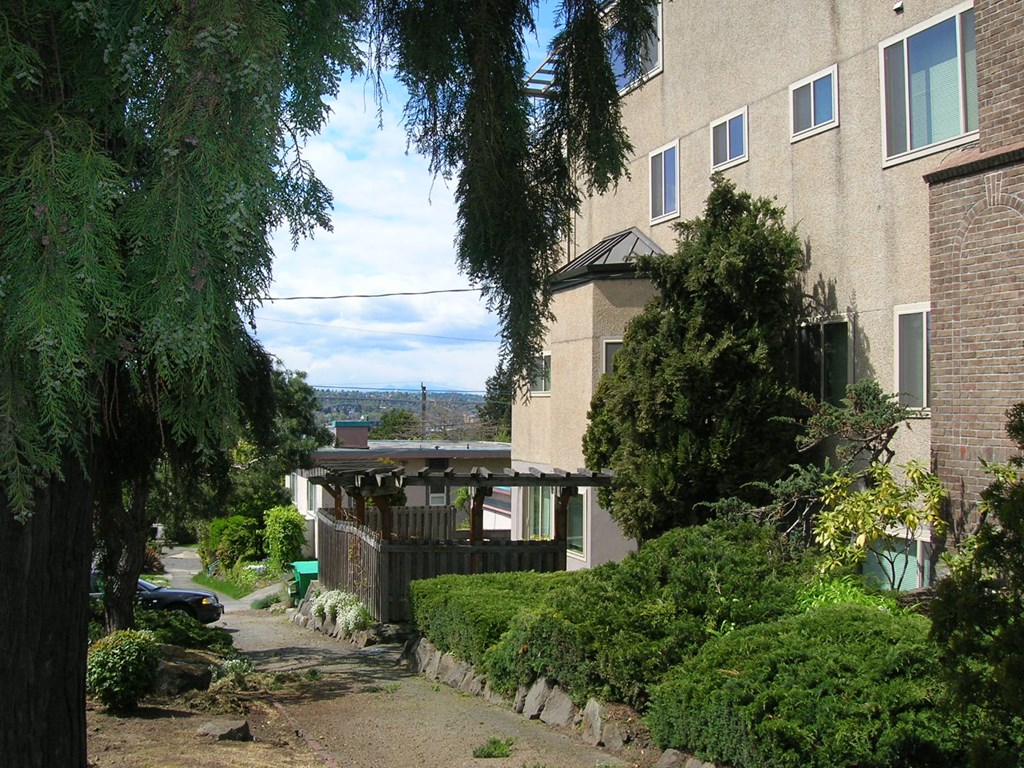 a city street with a house and a view in the distance