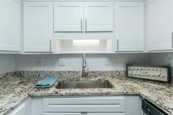 A kitchen with a marble countertop and a sign that says at Crest at East Cobb Apartments, Marietta
