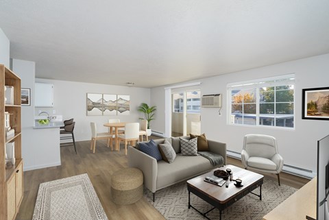 A living room with a grey couch, a wooden coffee table, and a white chair.