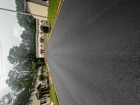 A street view of a residential area with houses on the left and a road on the right at Waverly Manor Townhomes, Norcross, GA 30071