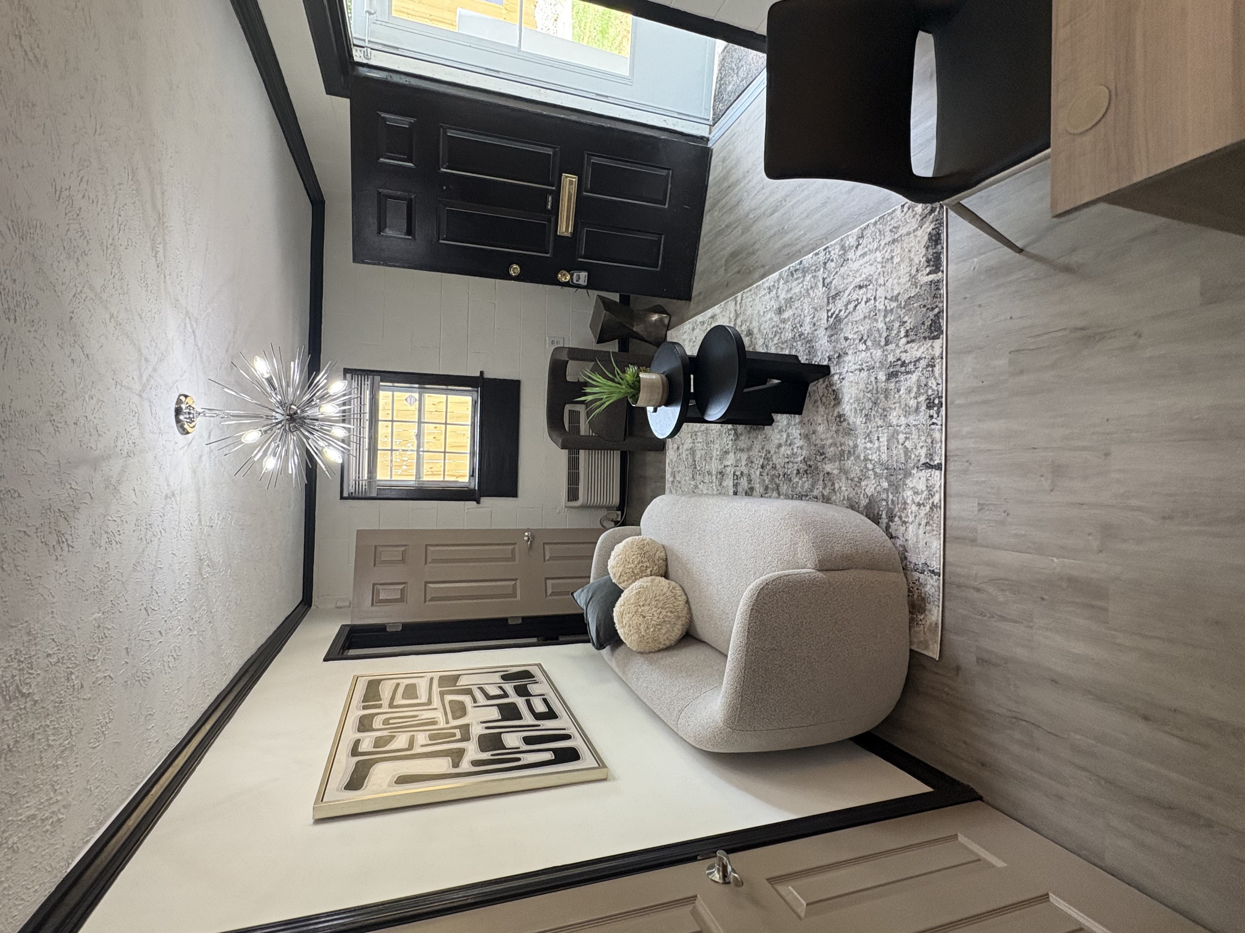 A modern living room with a grey sofa and a rug with the word "HOME" on it.