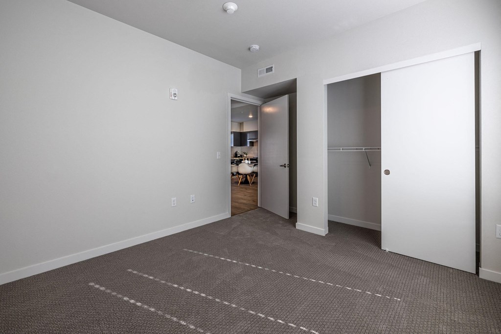 a living room with a carpet and a door to a closet at Sagecrest Apartments, Wenatchee, WA