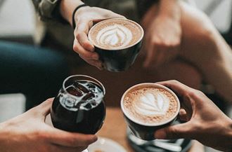 a group of people holding cups of coffee