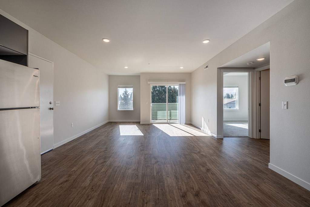 an empty living room with white walls and wood flooring at Sagecrest Apartments, Wenatchee