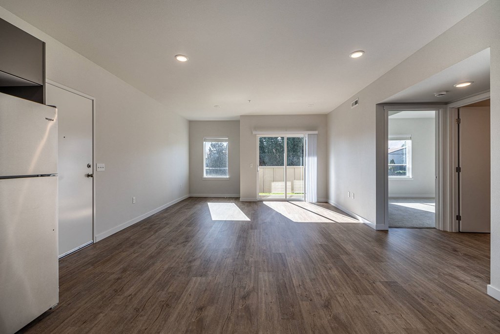 Living room with white walls and wood flooring at Sagecrest Apartments, Washington