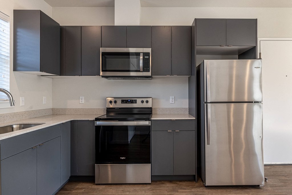 a kitchen with stainless steel appliances and black and silver cabinets at Sagecrest Apartments, Wenatchee, Washington