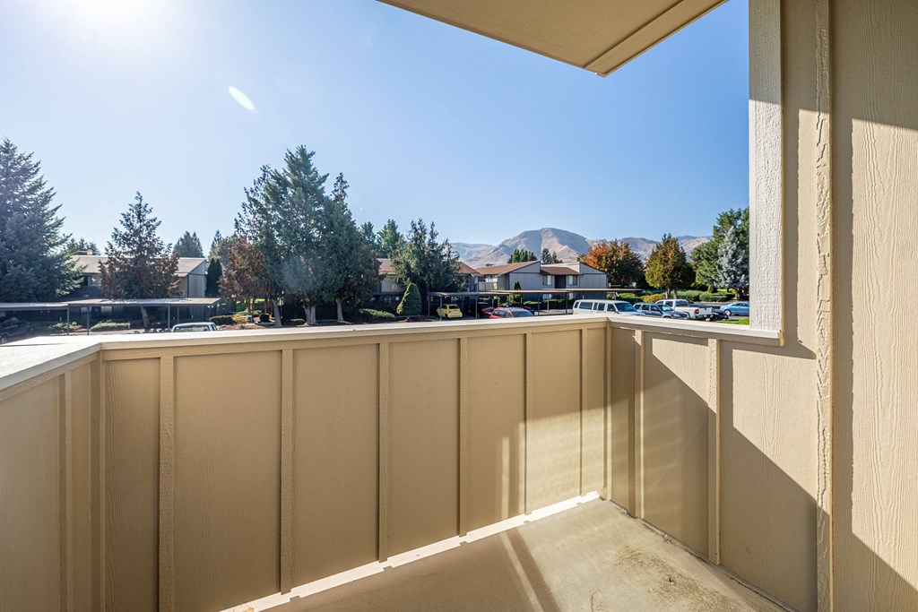 the view from the balcony of a condo with a view of the street and trees at Sagecrest Apartments, Wenatchee, Washington