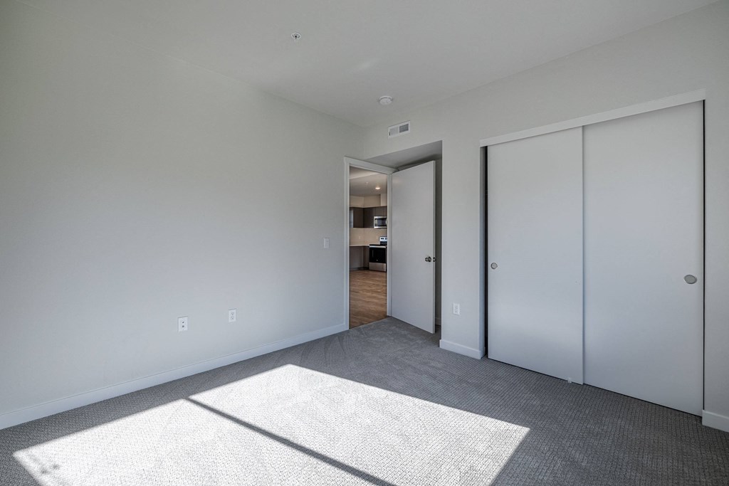 a living room with white walls and white closet doors at Sagecrest Apartments, Wenatchee, WA