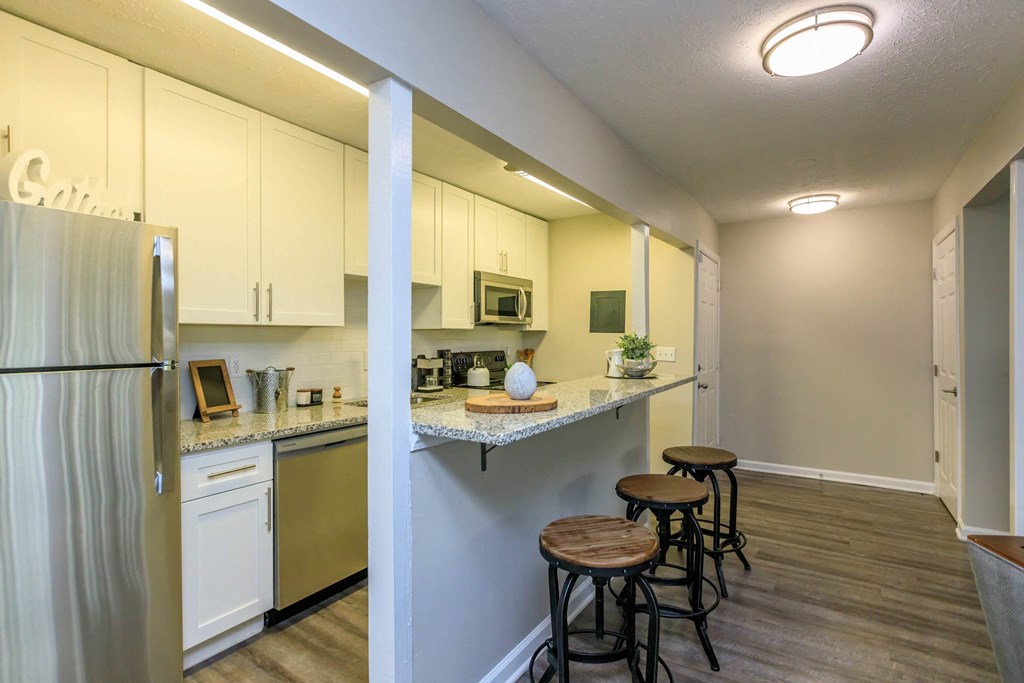 A kitchen with white cabinets and a refrigerator.at 400 Winchester, Atlanta Georgia