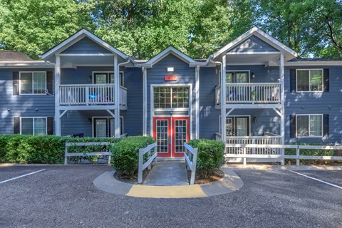 A building with a red door and a white fence in front at Crest at East Cobb Apartments, Marietta, GA
