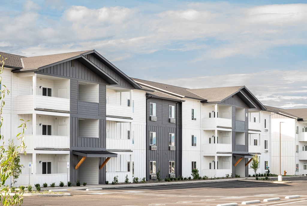 a row of white and gray apartment buildings with a parking lot at Gateway Apartments, Washington, 98802